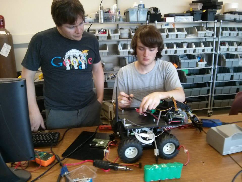 The Agency co-founder, Jesse Rosalia (left), works with Nick Johnson on the robot in 2014.